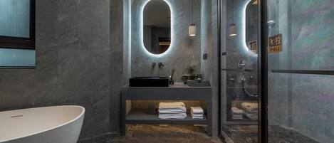 Une salle de bain moderne avec une baignoire sur pieds, un meuble-lavabo avec miroir et une douche à l’italienne.