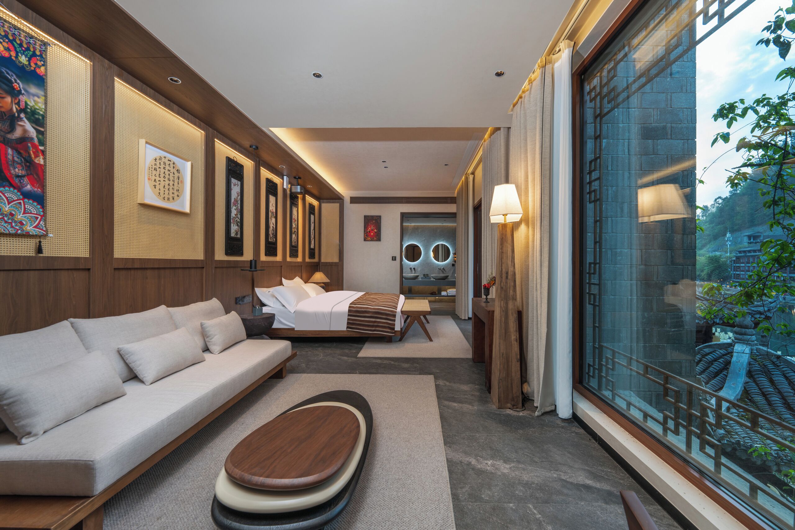 Ein modernes Hotelzimmer mit einer Couch, einem Bett, einem Holztisch und einem großen Fenster mit Blick auf traditionelle Architektur.