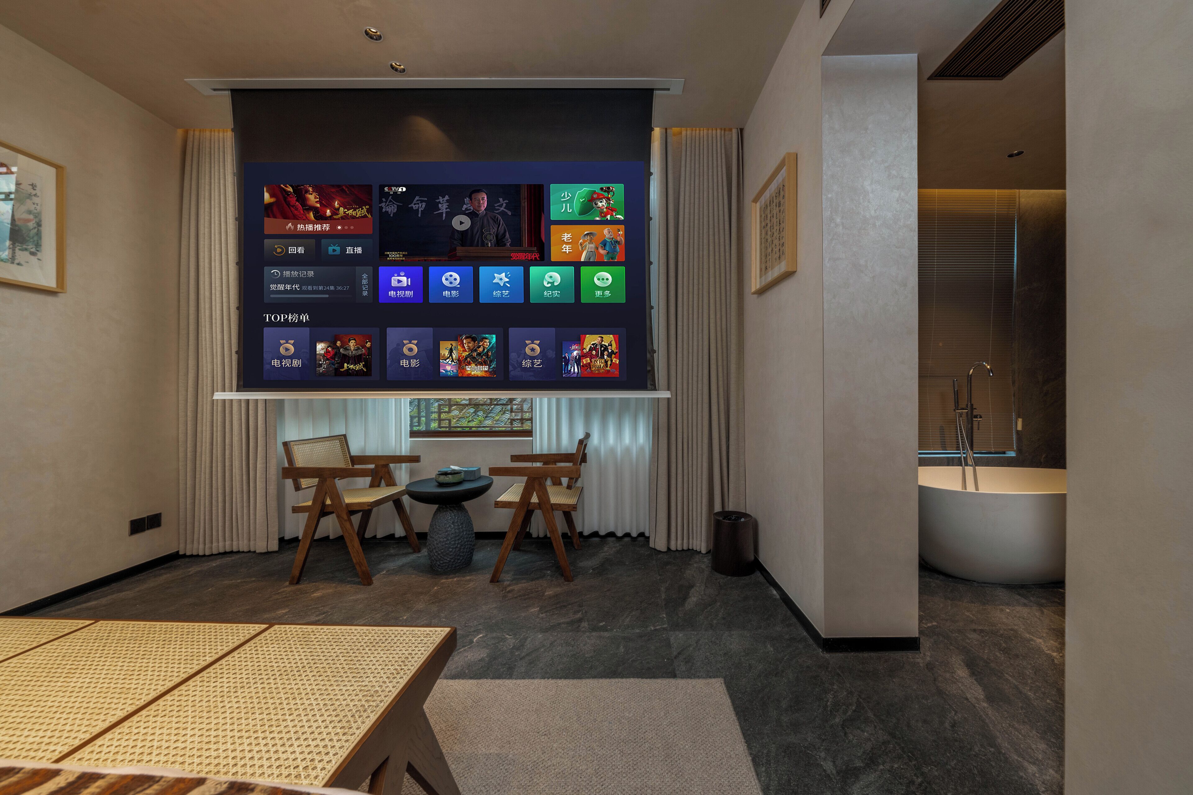 A modern hotel room with a large digital screen displaying various game icons, a seating area with a small round table, and a bathtub.