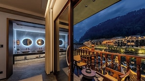 Interior moderno de un hotel con vistas a edificios tradicionales y un balcón con muebles de madera.