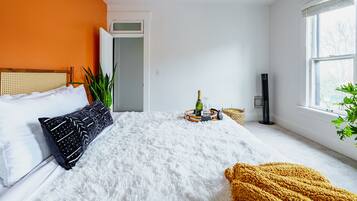Un dormitorio con cama, ventilador de techo, ventana y puerta.