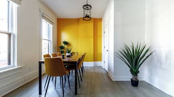 A dining area with a table, chairs, and a potted plant.