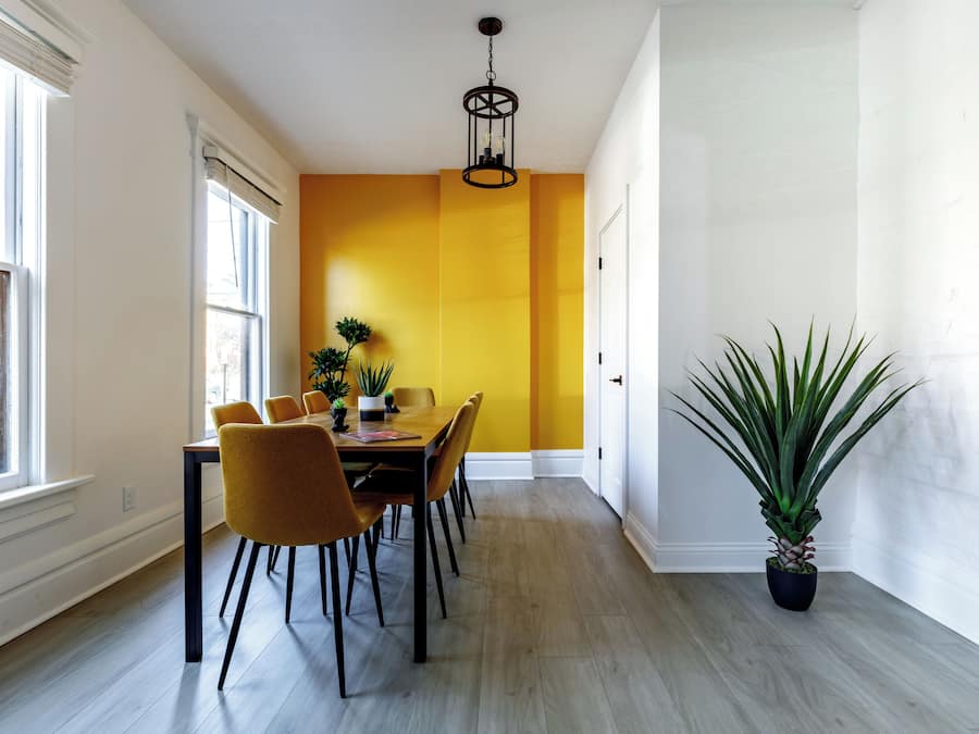 A dining area with a table, chairs, and a potted plant.
