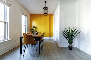 A dining area with a table, chairs, and a potted plant.