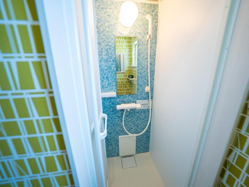 A small bathroom with a shower, a mirror, and a toilet.