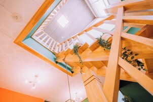 Una scala in legno a più piani con vista sul piano superiore.