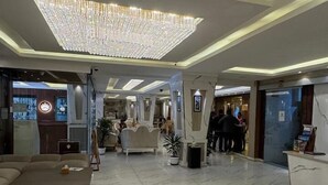 A spacious lobby with a large chandelier, marble flooring, and seating areas. - Maharaja The Royal Hotel (Pokhara)