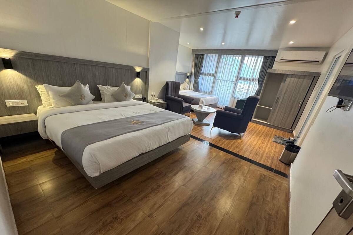 A modern hotel room with a large bed, a desk, and a chair.