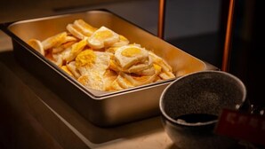 Una bandeja con alimentos, probablemente desayuno, sobre una mesa.