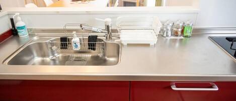 Una cocina moderna con un lavamanos de acero inoxidable, un escurreplatos y un juego de armarios.