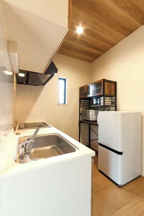 Kylskåp, mikrovågsugn, spishäll och grytor/köksredskap