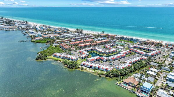 An aerial view of a coastal resort with multiple buildings, a marina, and a beach. - Closest to Beach • New Remodel • Pickleball Tennis (Bradenton Beach)