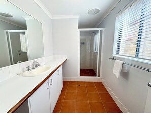 Chuveiro, secador de cabelo, toalhas de banho, shampoo