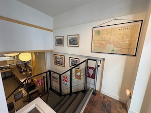 Un escalier orné d’une carte et de photos encadrées accrochées aux murs.