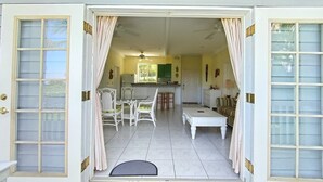 A spacious living area with a dining table, chairs, a sofa, and a kitchen in the background.