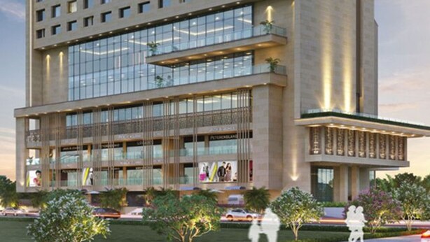 A modern hotel with a prominent 'SAROVAR' sign, multiple floors, large windows, and a well-lit facade. - Sarovar Premiere Alwar (Alwar)