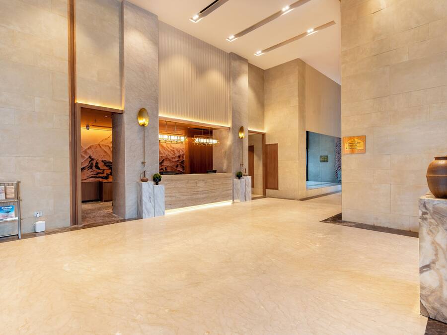 A spacious lobby with marble flooring, a reception desk, and a modern reception area.