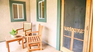 Un espace patio aménagé avec du mobilier en bois et agrémenté d’une pancarte de bienvenue.