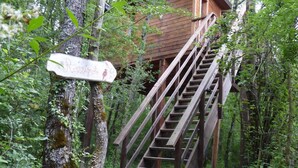 A wooden staircase leading to a cabin in a forested area. - Cabanes Sainte Camelle (Saint Victor Rouzaud)