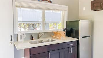 Coffee/tea maker, toaster, cookware/dishes/utensils, dining tables