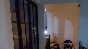 Un couloir avec une plante en pot, une chaise et une table.