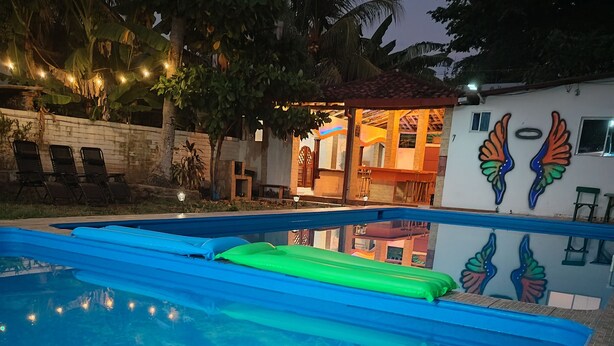 Une piscine dont le bord est recouvert de carrelage, entourée d’un mur de briques et agrémentée d’un palmier.
