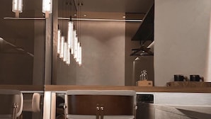 A modern kitchen with a wooden dining table and chairs, a built-in oven, and pendant lighting. - Here Hotel - Pingtung A (Pingtung)