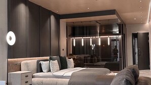 A modern living room with a large sectional sofa, a glass partition, and recessed lighting. - Here Hotel - Pingtung A (Pingtung)
