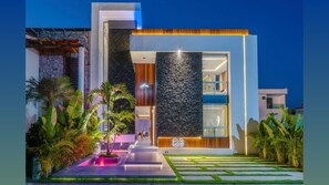 Un bâtiment moderne doté d’une grande façade en verre, d’un mur en pierre et d’une enseigne lumineuse au néon.