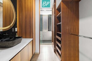 A narrow hallway with wooden cabinets and a vanity with a sink. - Villa 83: 3BR, 2 Private Pools & Beach Club Access (Cruz de Huanacaxtle)