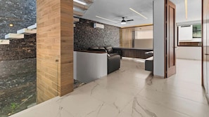 A modern interior with a stone wall, wooden panel, and a seating area with a sofa and a table.