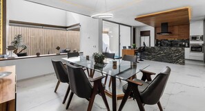 A modern kitchen with a marble countertop, wooden cabinets, and a black range hood. - Villa 83: 3BR, 2 Private Pools & Beach Club Access (Cruz de Huanacaxtle)