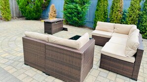 Un patio con mobiliario de mimbre, incluyendo dos sofás y una pequeña mesa.