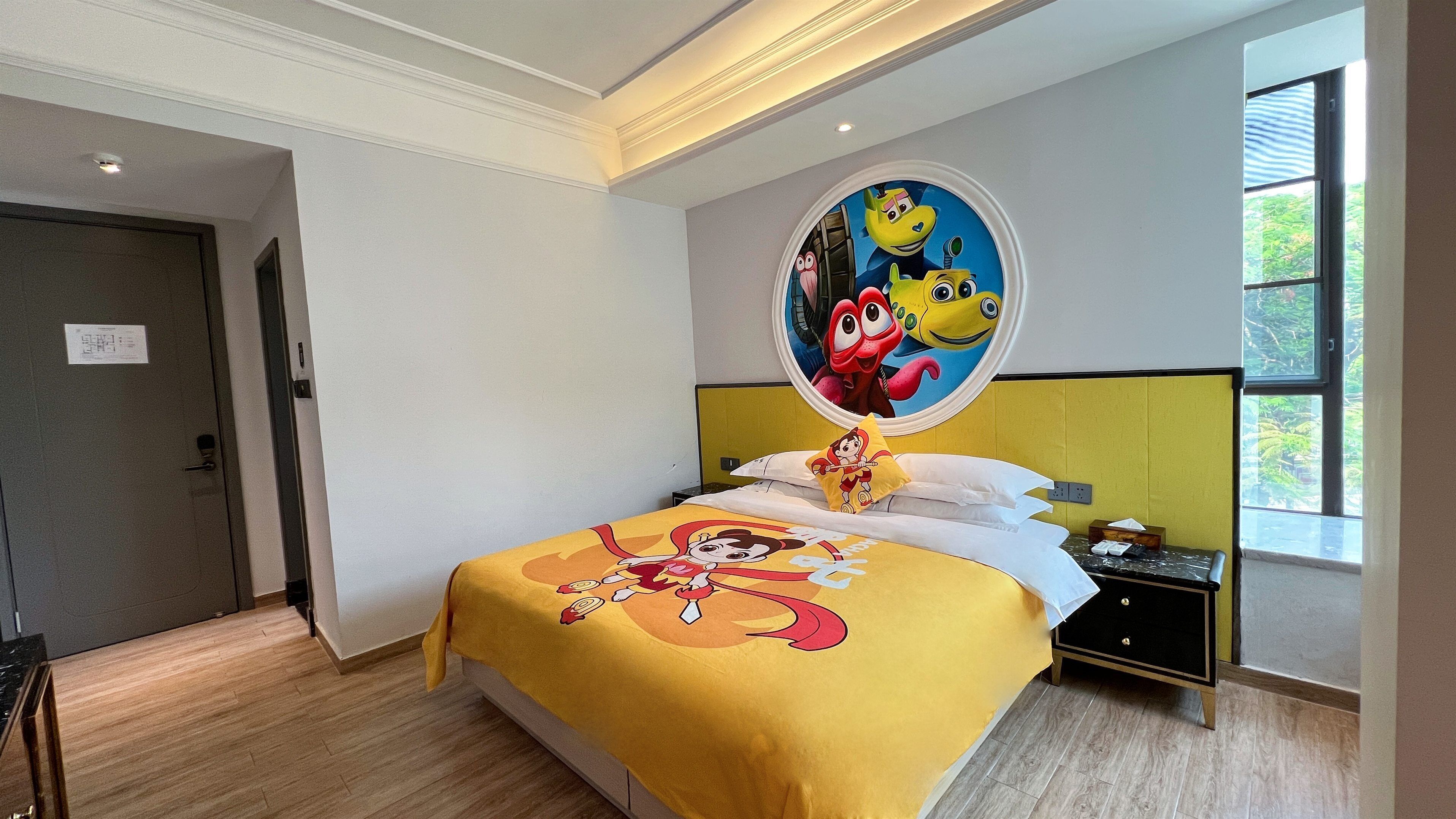 Habitación de hotel con cama, mesita de noche, ventana y puerta.