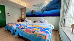 A hotel room with a large bed featuring a colorful sea-themed bedspread, a mural of marine life on the wall, and a view of the sea through the window. - Zhuhai Yujia Boutique Homestay (Zhuhai)