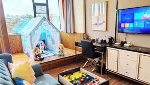 A cozy living room with a play area, a TV, and a desk with a computer. - Zhuhai Yujia Boutique Homestay (Zhuhai)