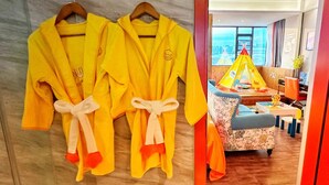 A hotel room with a bed, a window with a view, and a small play area with a tent and toys. - Zhuhai Yujia Boutique Homestay (Zhuhai)