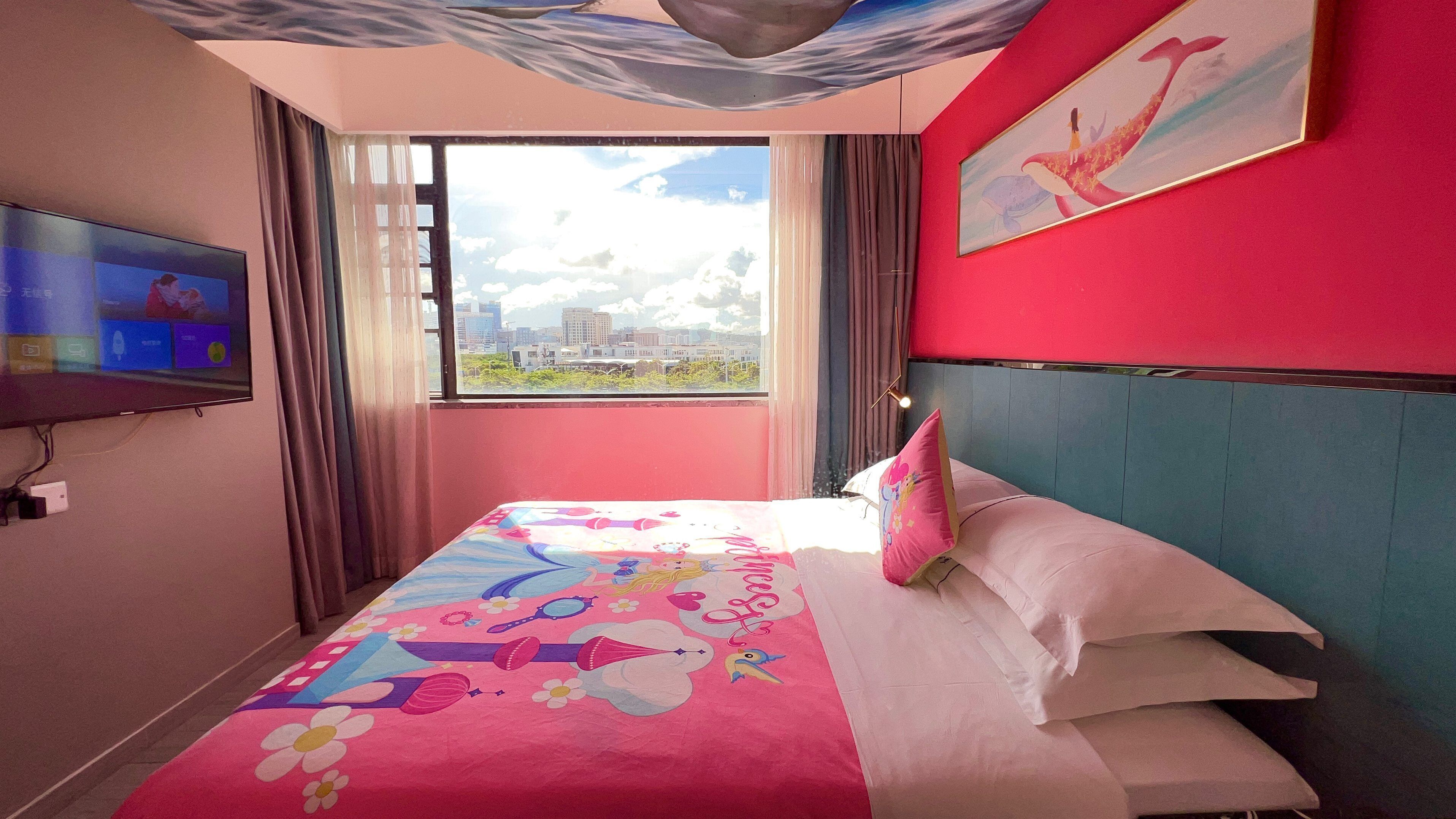 Habitación de hotel con una cama, televisión, ventana con vista a la ciudad y un cuadro en la pared.
