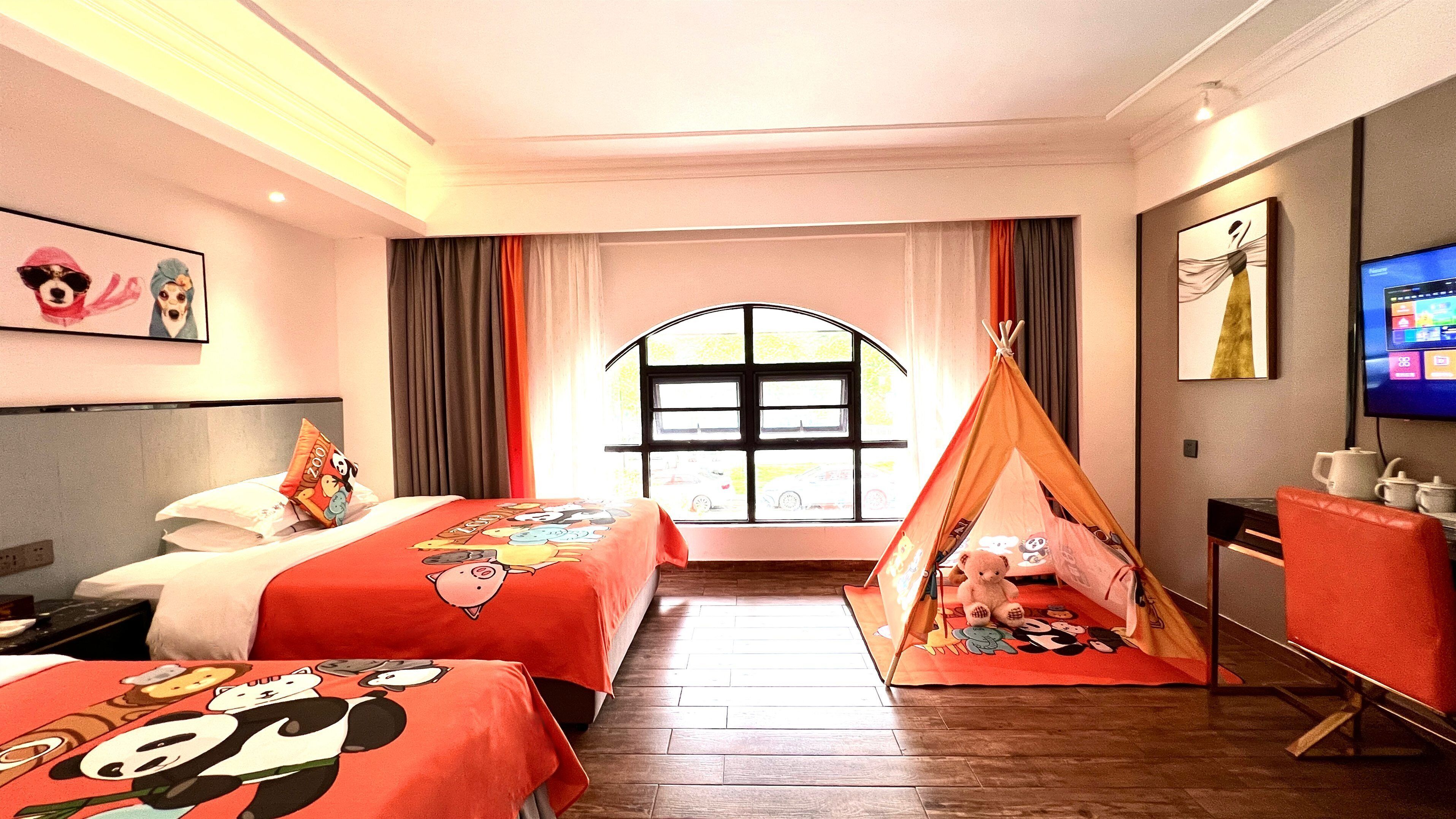 Een hotelkamer met twee bedden, een televisie, een raam en een tentachtige constructie.