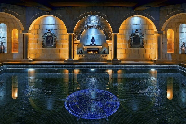 Sink into a tranquil pool beneath glowing arches and mosaics.