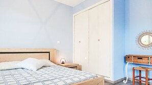 A bedroom with a wooden bed, a nightstand, a dresser, and a wardrobe. - La siesta by Interhome (Six Fours)