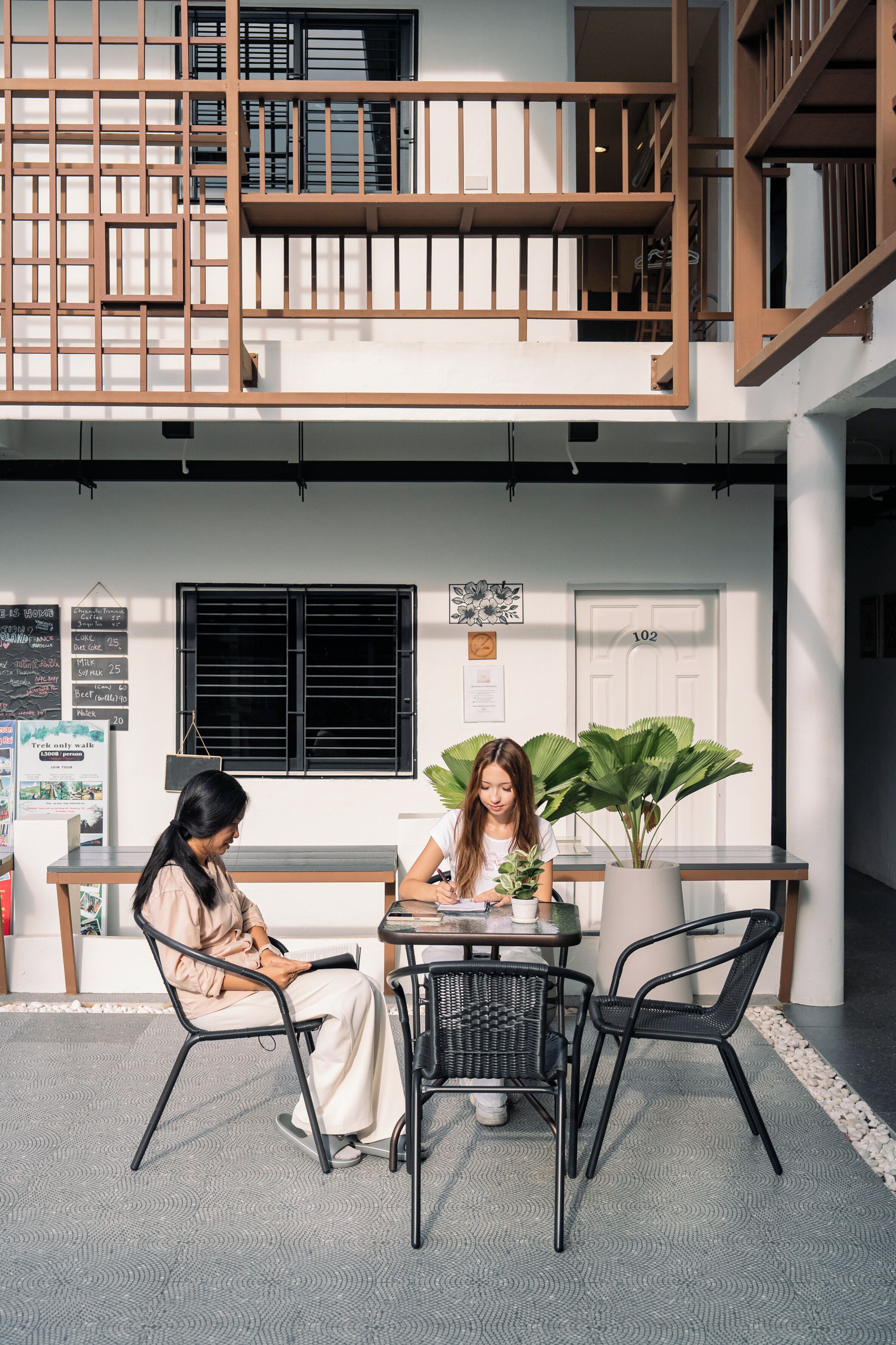 Un interno moderno con un balcone a due livelli, una reception e una pianta in vaso.