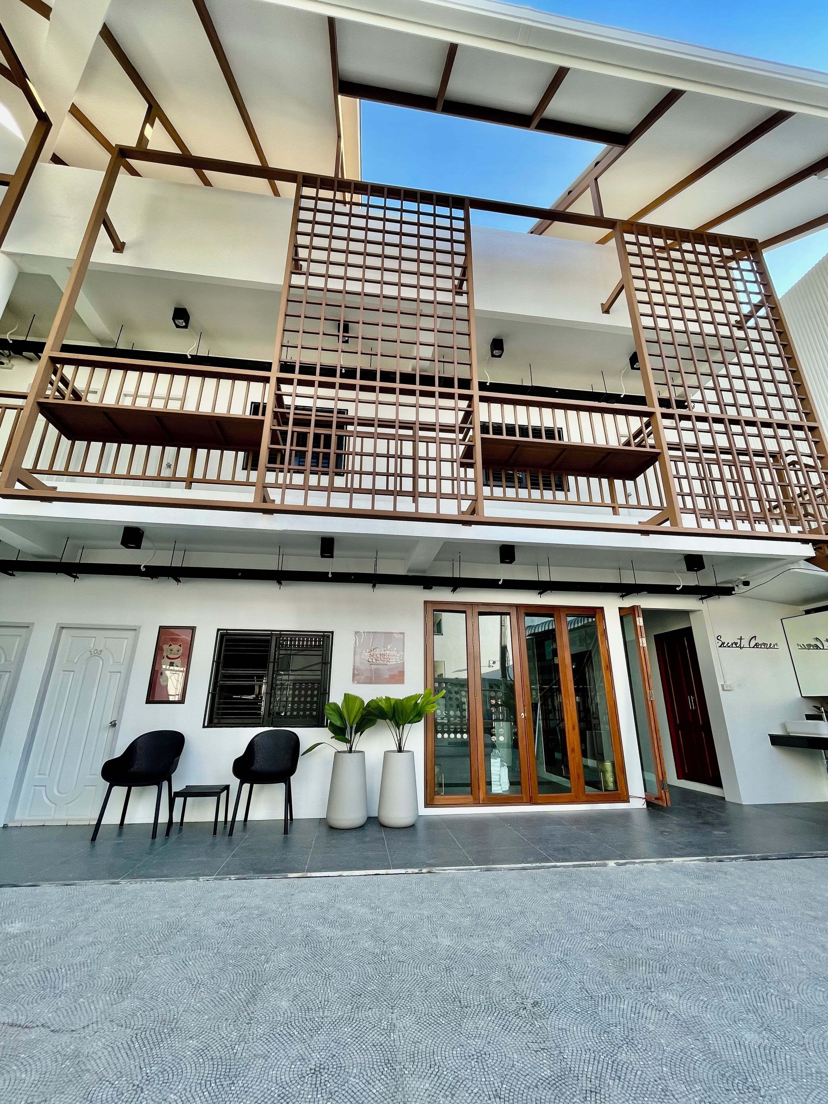 Un bâtiment à deux étages doté d’un balcon, d’un espace d’accueil avec un comptoir et d’une porte portant l’inscription « Cour secrète ».