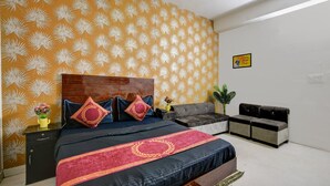 Quarto com cama, mesa de cabeceira, cômoda e sofá.