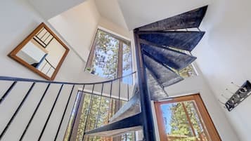 A spiral staircase with a modern design, leading to an upper floor.