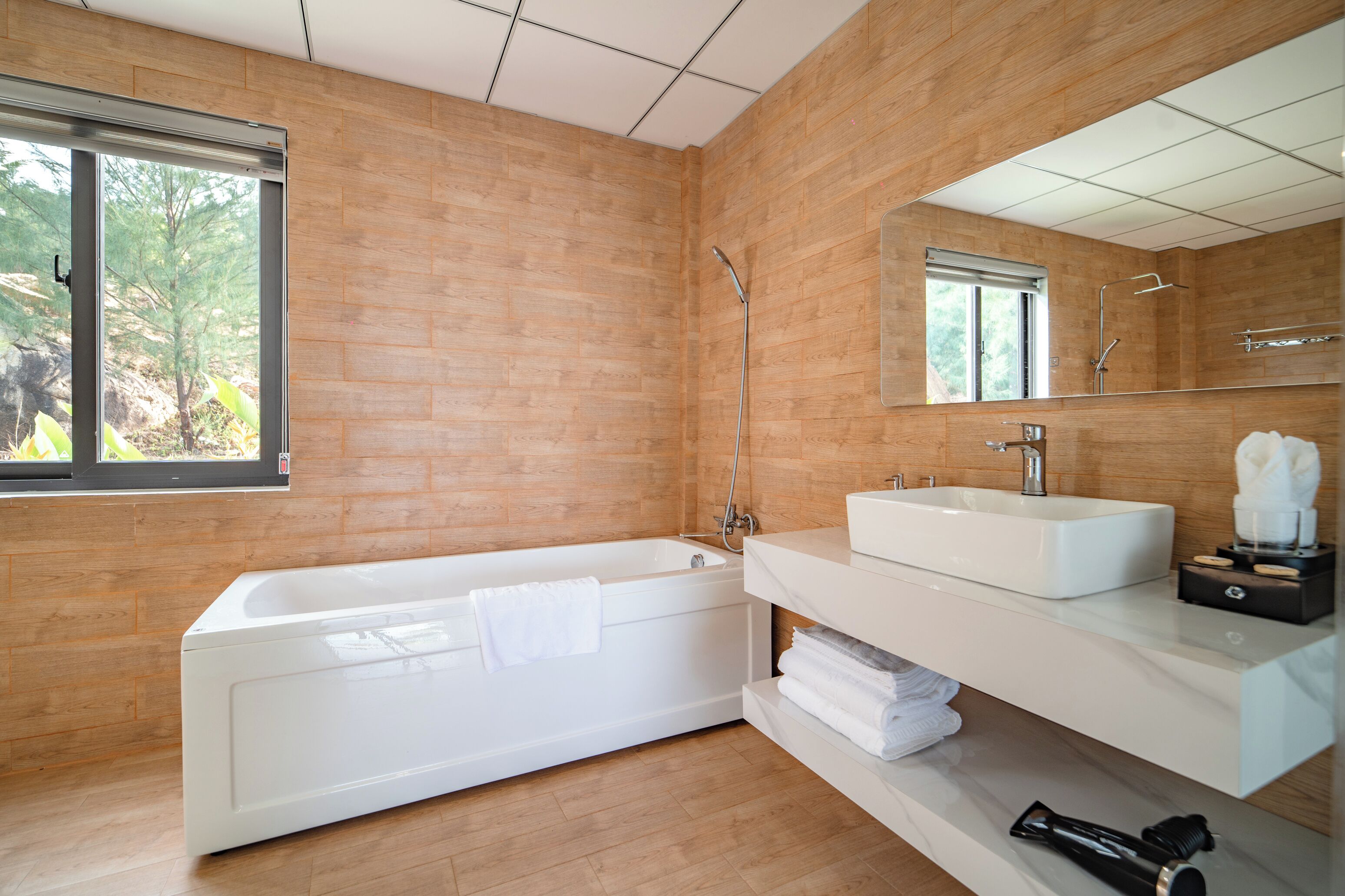 Een moderne badkamer met een groot bad, een wastafel en een spiegel.