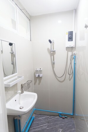 A small, modern bathroom with a shower, a sink, and a mirror. - Bangkok Cozy Home at Khaosan Road (Bangkok)