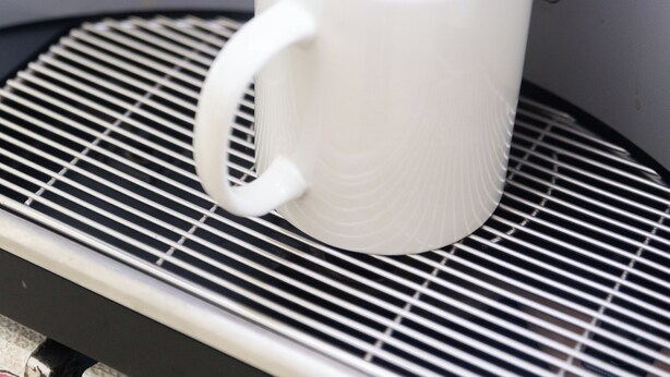 A white mug on a metal tray with a beverage being poured into it. - Bangkok Cozy Home at Khaosan Road (Bangkok)