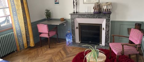 A cozy room with a fireplace, a dining area, and a bed.
