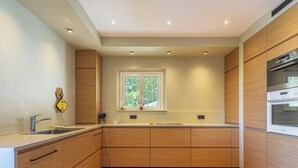 Une cuisine moderne avec des meubles en bois, un évier en acier inoxydable et un four encastré.